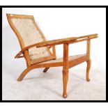 A 20th Century vintage hardwood Plantation chair / armchair with 2 slide out arms being raise on