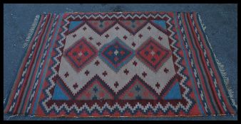 An early 20th century Persian rug with central medallions, geometric borders having cream, blue