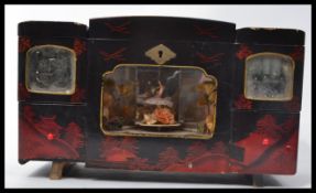 A vintage 20th century musical Japanese jewellery box with dancer to inside. Inset mirrors above