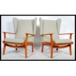 A 1970's retro vintage teak wood wingback three piece suite comprising of a pair of wingback