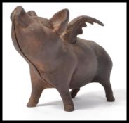 A vintage 20th Century cast metal pig ( Pigs might fly ) with wings money box, wings outstretched