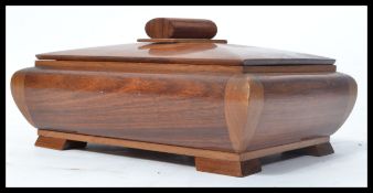 A good 20th century wooden tobacco box of sarcophagus form raised on square stub feet with log final