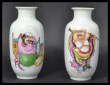 A pair of 19th century Chinese miniature vases depicting two Buddhas one in robe and one holding a