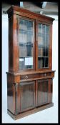 A Victorian mahogany library bookcase cabinet raised on plinth base with cupboard and short drawer