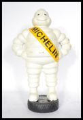 A transport interest advertising cold cast metal figure of the Michelin man standing on a tyre