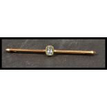 A 9ct gold bar brooch set with an oval cut pale bl