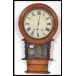 A 19th century Victorian American walnut wall clock having a carved pediment with turned columns.