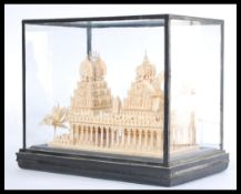 A 20th Century cased Asiatic temple carving modelled from balsa wood encased within a good glazed