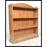 An antique style large open window country pine bookcase cabinet having a plinth base with a