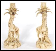 A pair of 19th Century Continental figure groups modelled as Giraffes feeding from trees. Measures