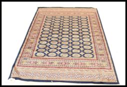 An early 20th century Persian handwoven Bokhara rug having central multiple medallions raised on