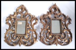 A good pair of Florentine style gilt wood carved wall mirrors.  Each with a rectangular plate mirror