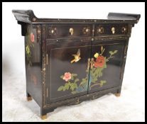 A Japanese ebonised lacquered alter style sideboard with raised sides and fretwork supports,