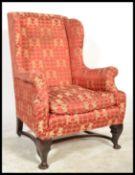 A 19th Century Georgian wingback armchair, the shaped toprail above a padded back and deep wings,
