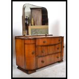 A 20th century walnut Art Deco dressing table, having a series of drawers with mirror atop raised on