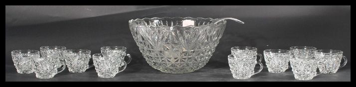 A vintage 20th Century glass punch bowl and glasses, complete with ladle and retaining it's original