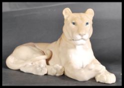 A Royal Copenhagen porcelain model, modelled as a recumbent  Lioness stamped to base. With early