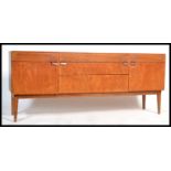 A 1970's Danish teak wood sideboard being raised on tapered legs with a series of drawers and