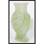 A Chinese jade vase raised on a pedestal base depicting dragons with twin dragon handles.