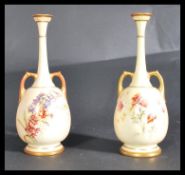 A pair of Royal Worcester blush ivory vases, decorated with floral sprays the baluster bodies raised