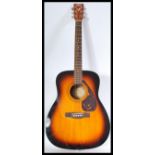 A 20th Century six string acoustic guitar by Yamaha, applied paper label reading Yamaha F370 TBS