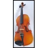 A vintage 20th century student violin with pierced hollow body and shaped neck and head. Makers