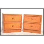 A pair of 20th century teak wood G-Plan bedside cabinet chests, each raised on plinth bases with