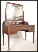 An Edwardian mahogany dressing table being raised on tapering square legs with castors having a