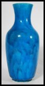 A 19th century Chinese monochrome bottle vase, glazed in merging tones of vibrant blue, elongated