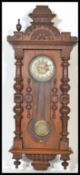 A 19th century Victorian Vienna Regulator wooden wall clock having carved columns with finial