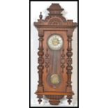 A 19th century Victorian Vienna Regulator wooden wall clock having carved columns with finial