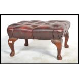 An antique style Chesterfield footstool having button backed oxblood leather top raised on