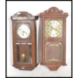 A 1920's oak cased wall clock with 8 day movement and silvered dial together with another
