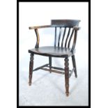 An early 20th century Beech and elm wood office Industrial desk chair / smokers bow armchair being