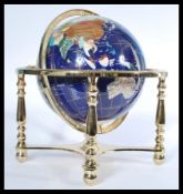 A contemporary desk top globe inlaid with lapis lazuli minerals and raised on a polished brass base