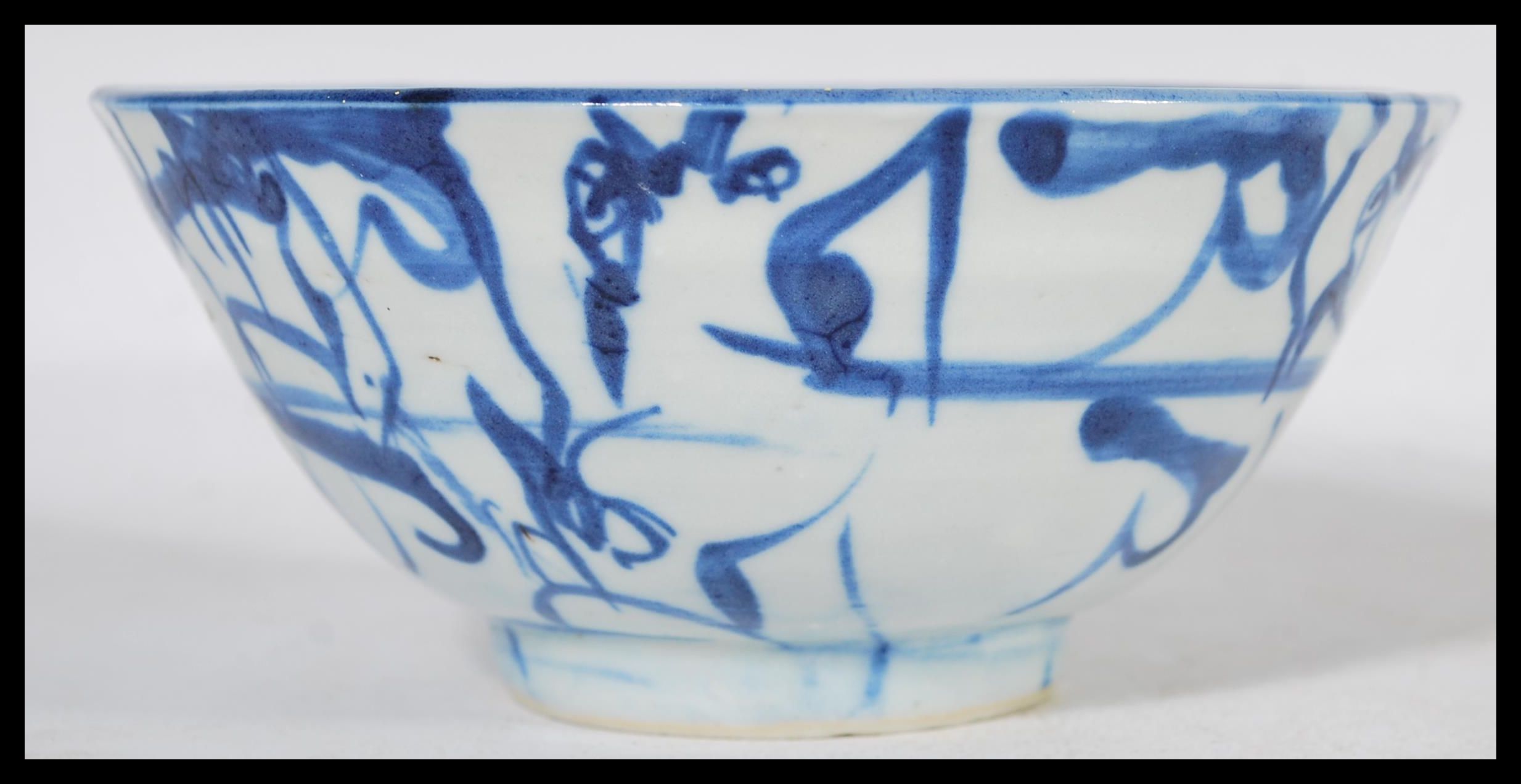 A 19th century Chinese pottery bowl raised on a small circular foot with hand painted decoration