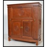 A 20th century Chinese hardwood oriental cupboard with articulated hinged top having mirror lined