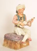 A 19th century Capodimonte Majolica figurine of a gent playing a lute seated on a cushion pedestal