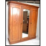 A Victorian 19th century mahogany linen press - triple wardrobe. Raised on a plinth base with a