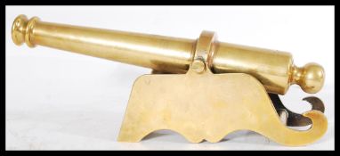 An early 20th century heavy brass desktop cannon raised on scrolled supports. Please see images.