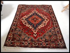 A 20th century large Persian - Islamic rug with red ground having geometric decoration and