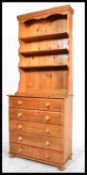 A 20th century antique style country pine dresser chest. Raised on bun feet with a chest of