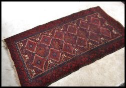 An early 20th Century Kelim floor rug / carpet on red ground, large central geometric panel with