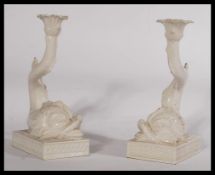 A pair of decorative 20th century Italian ceramic candlesticks in the form of mythical fish.
