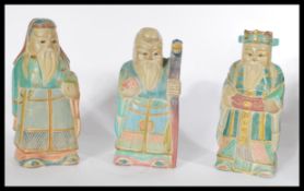 A group of three early 20th century carved wooden Chinese figures of deities / elders in coloured