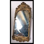 A mid century, circa 1950's rococo gilt wall mirror. The gilt frame with central rectangular wall