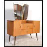 A 1960's retro oak drop centre dressing table being raised on tapering legs with a large mirror of