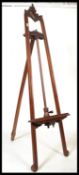 A good 20th century mahogany artists easel of tall folding form having threaded adjustable rest to