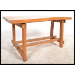 A retro mid 20th Century live edge elm topped coffee table raised on block supports united by twin