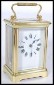 An early 20th century gilt brass French carriage clock having a white enamel face with Roman numeral